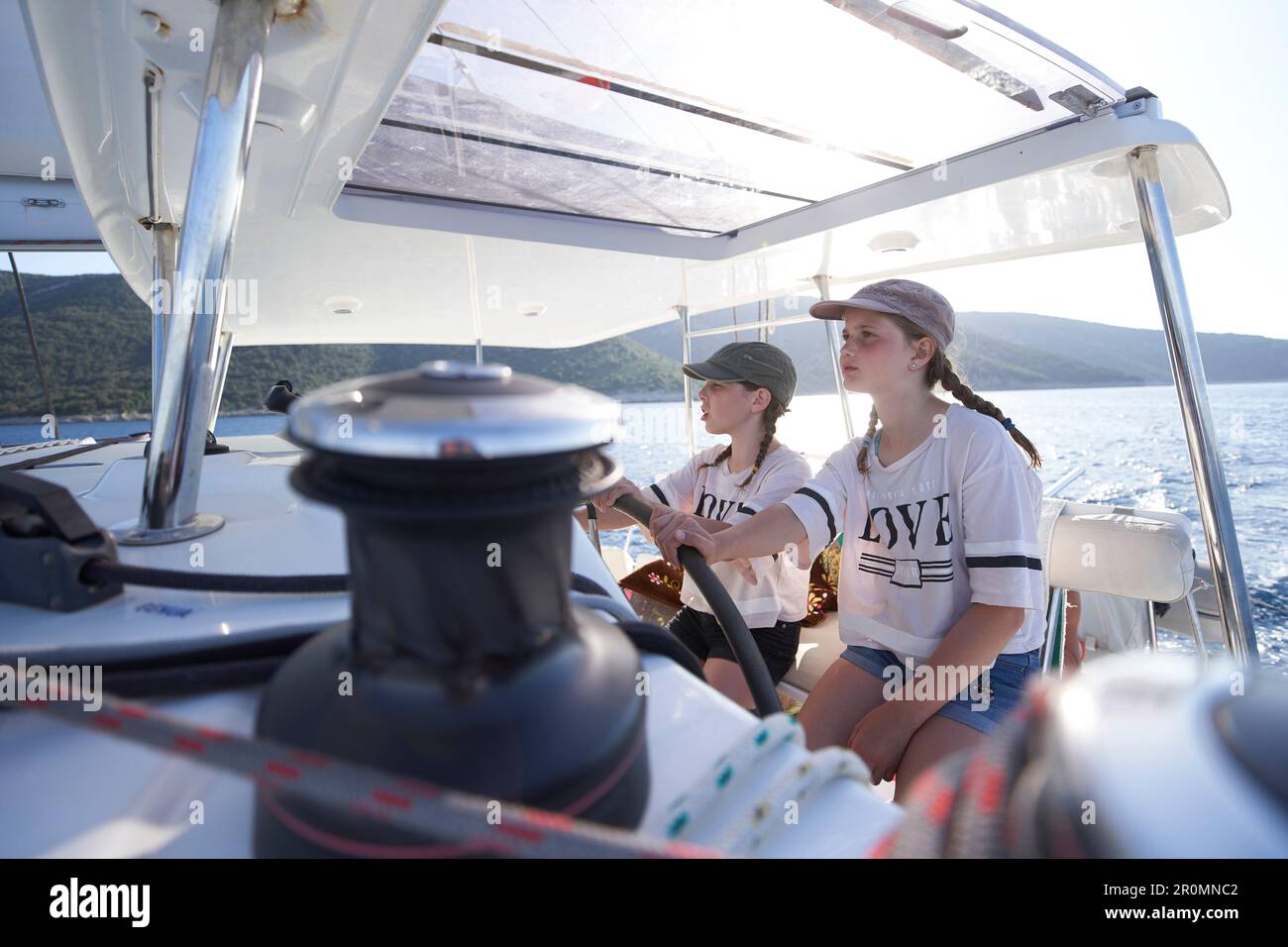 2 filles à la barre, catamaran EOS au large de la côte ouest de Cres, baie de Kvarner, Croatie Banque D'Images