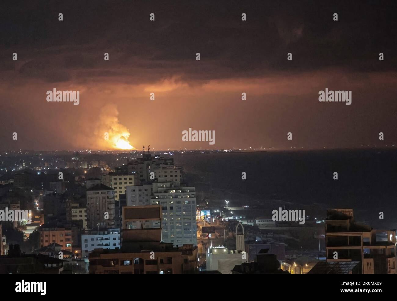 Gaza. 09th mai 2023. La fumée et les flammes s'élèvent au-dessus des bâtiments après une frappe aérienne israélienne dans la ville de Gaza, dans les Territoires palestiniens. Selon le ministère de la Santé du territoire contrôlé par le Hamas, des frappes aériennes israéliennes ont tué 13 personnes avant l'aube à 9 mai 2023, dans la bande de Gaza. L'armée israélienne a annoncé qu'elle avait mené des frappes contre des "cibles du Jihad islamique" palestinien dans la région. L'armée israélienne affirme avoir tué trois hauts commandants du groupe militant du Jihad islamique dans des frappes aériennes ciblées. Crédit : SOPA Images Limited/Alamy Live News Banque D'Images