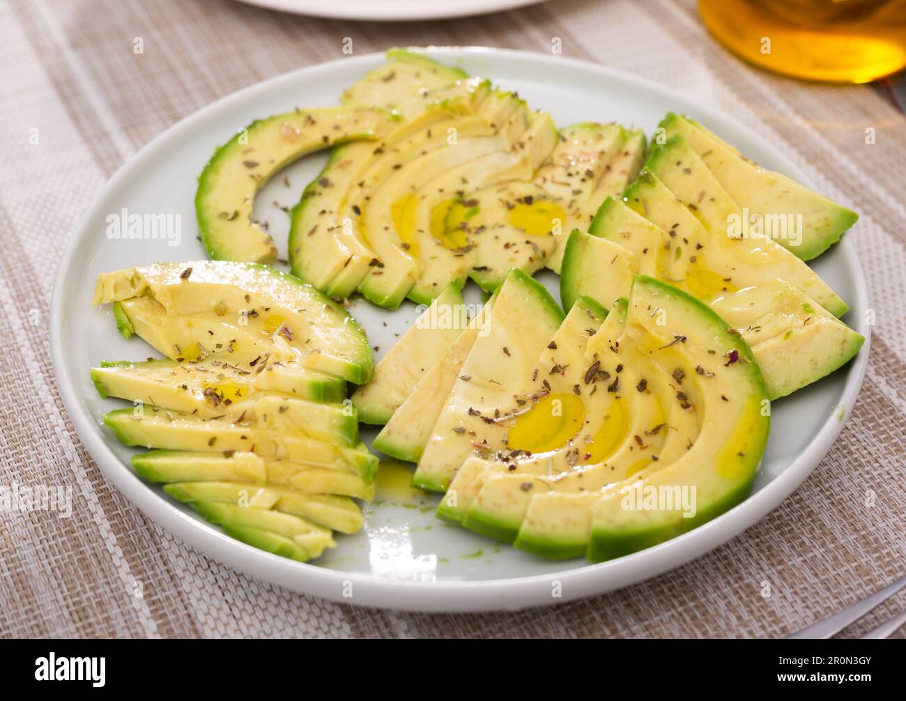 pulpe d'avocat mûre coupée en morceaux saupoudrée de jus de citron sur une assiette Banque D'Images