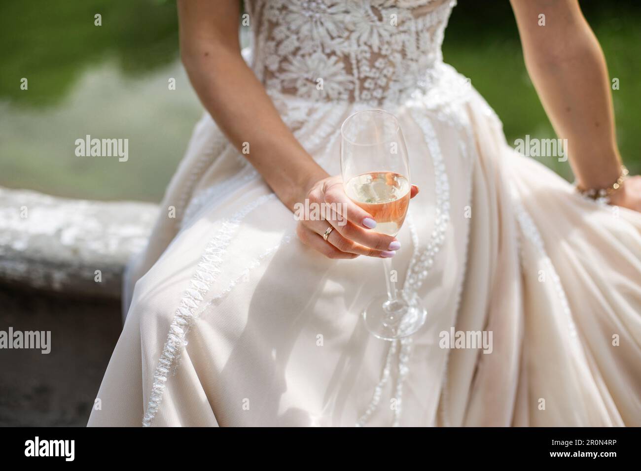 Mariée tenant un verre de champagne à la main, portant une belle robe de mariage. Jour de mariage Banque D'Images