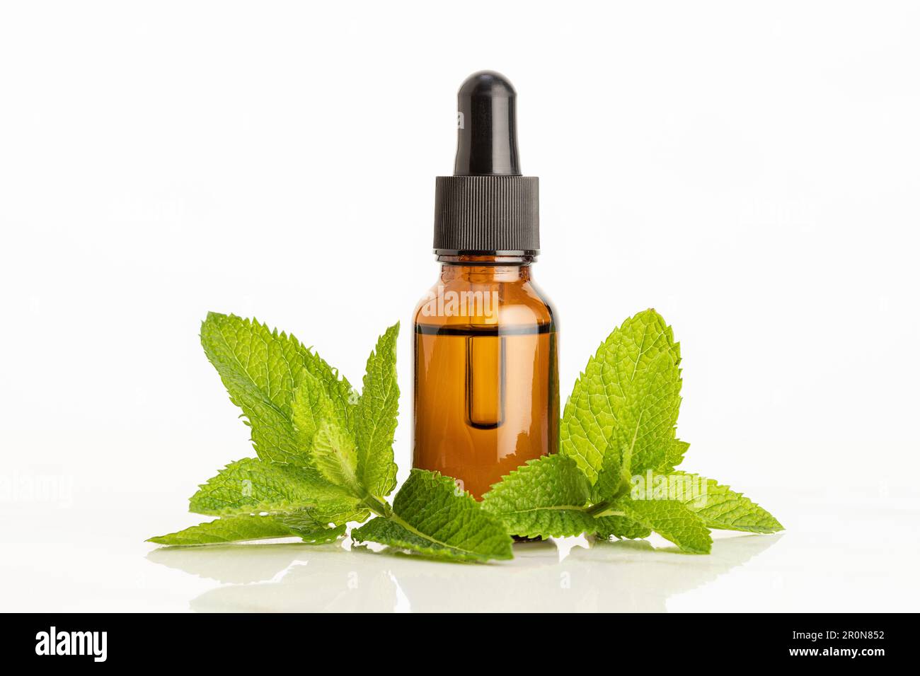 Huile essentielle de menthe poivrée sur fond blanc. Remèdes à base de plantes Banque D'Images