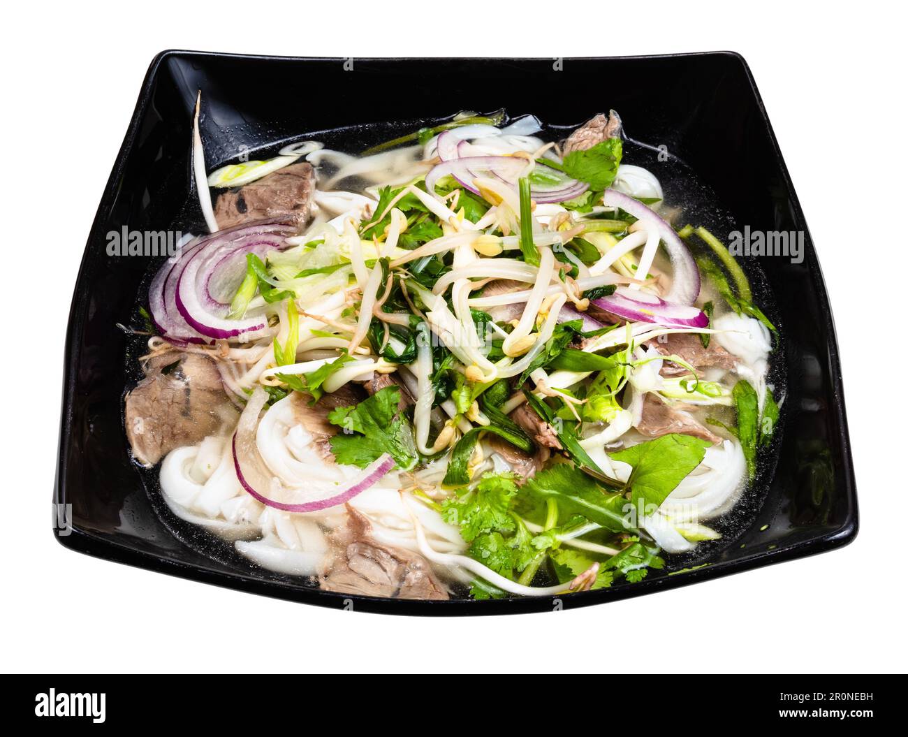 Soupe vietnamienne Pho Bo avec nouilles de riz, bouillon, oignon, légumes verts, bœuf dans un bol découpé sur fond blanc Banque D'Images