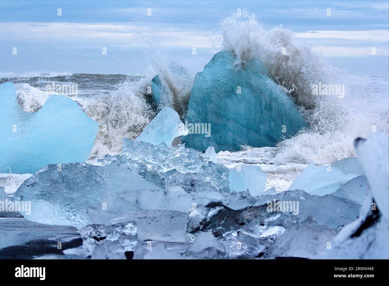 Une vague se brisant sur les icebergs de Black Diamond Beach dans le sud-est de l'Islande, Breidamerkursandur, Islande, Europe Banque D'Images