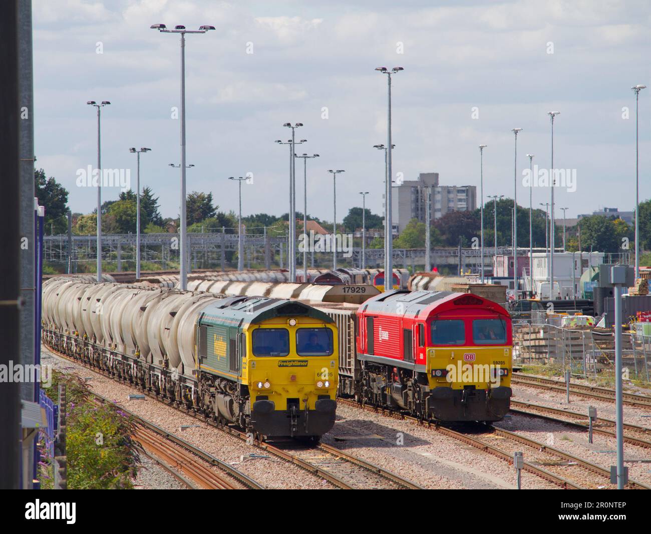 A classe Freightliner classe 66 numéro 66605 réservoirs de ciment vides de travail qui passent DB Cargo UK classe 59 numéro 59205 avec un train de pierre chargé. Cour d'Acton. Banque D'Images
