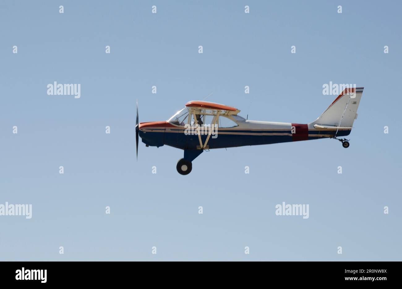 Un seul avion à hélice qui traverse un ciel bleu clair sans nuages en vue Banque D'Images