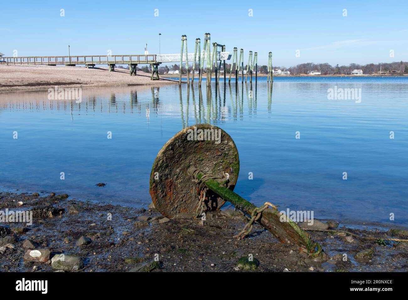 Vue sur les eaux à marée basse de Greenwich Cove avec un quai et une longue rangée de poteaux d'amarrage qui s'élèvent au-dessus de l'eau de Tod's point, Greenwich, CT, USA Banque D'Images