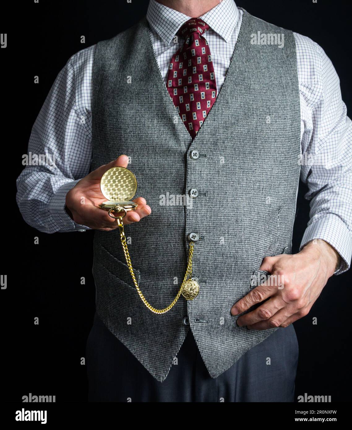 Portrait d'un homme en tweed Vest ou gilet de costume tenant une montre de poche. Style vintage et mode rétro de gentleman anglais classique. Banque D'Images