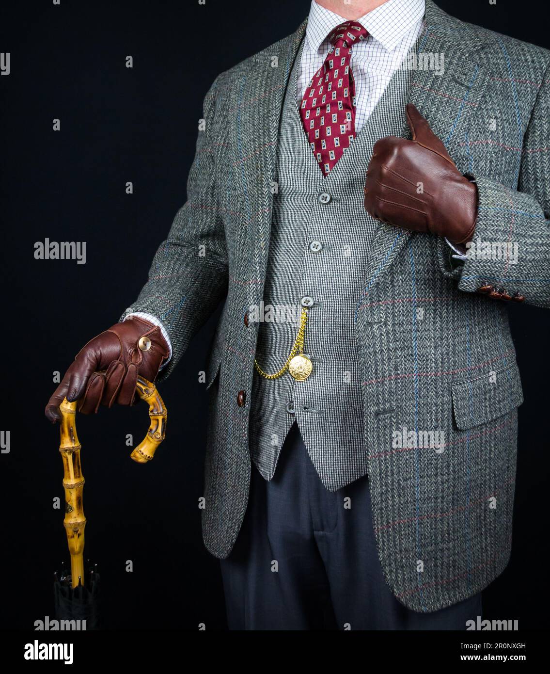 Portrait de l'homme en costume en tweed et gants en cuir tenant un parapluie. Style vintage et mode rétro de gentleman anglais classique. Banque D'Images