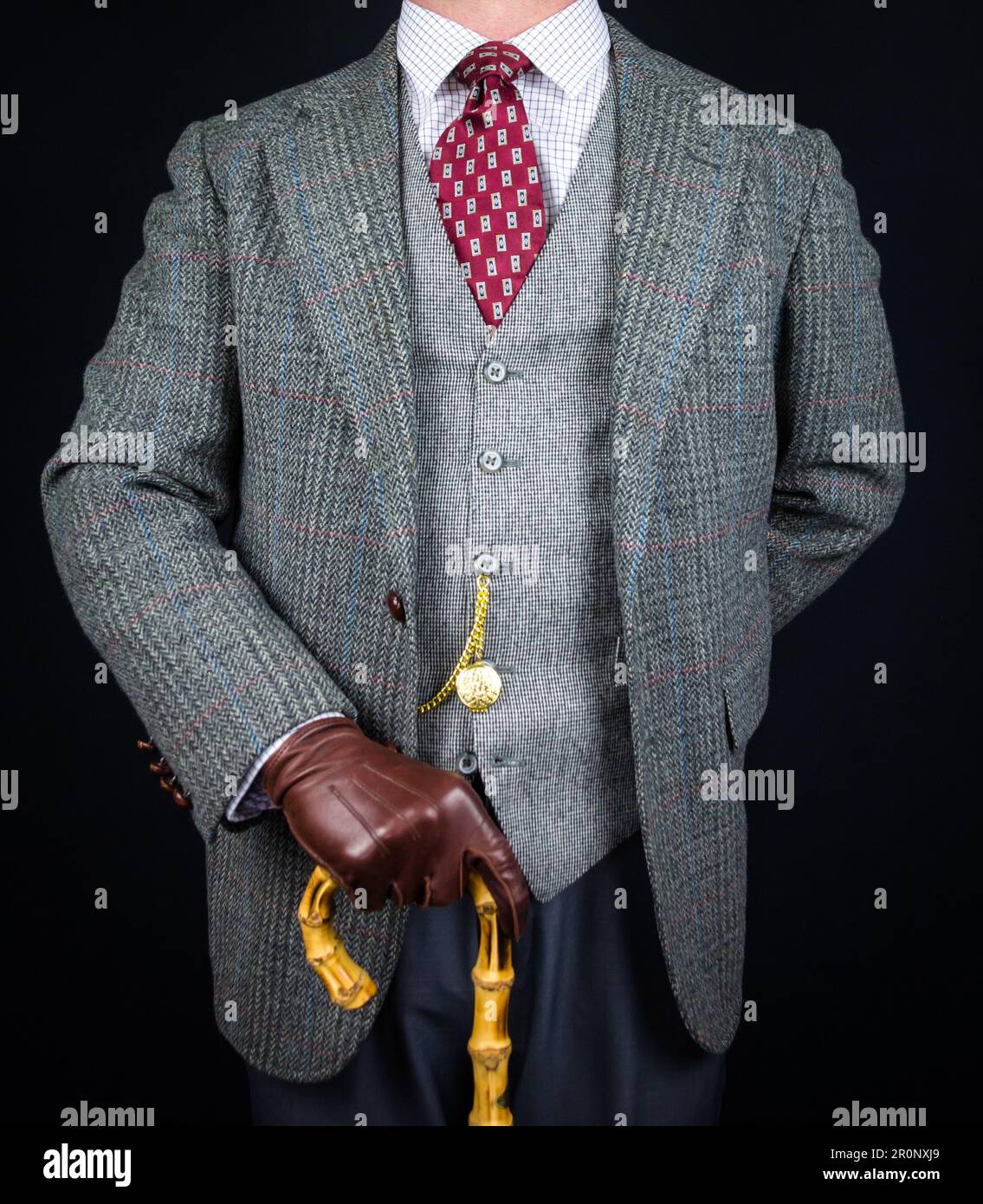 Portrait de l'homme en costume en tweed et gants en cuir tenant un parapluie. Style vintage et mode rétro de gentleman anglais classique. Banque D'Images