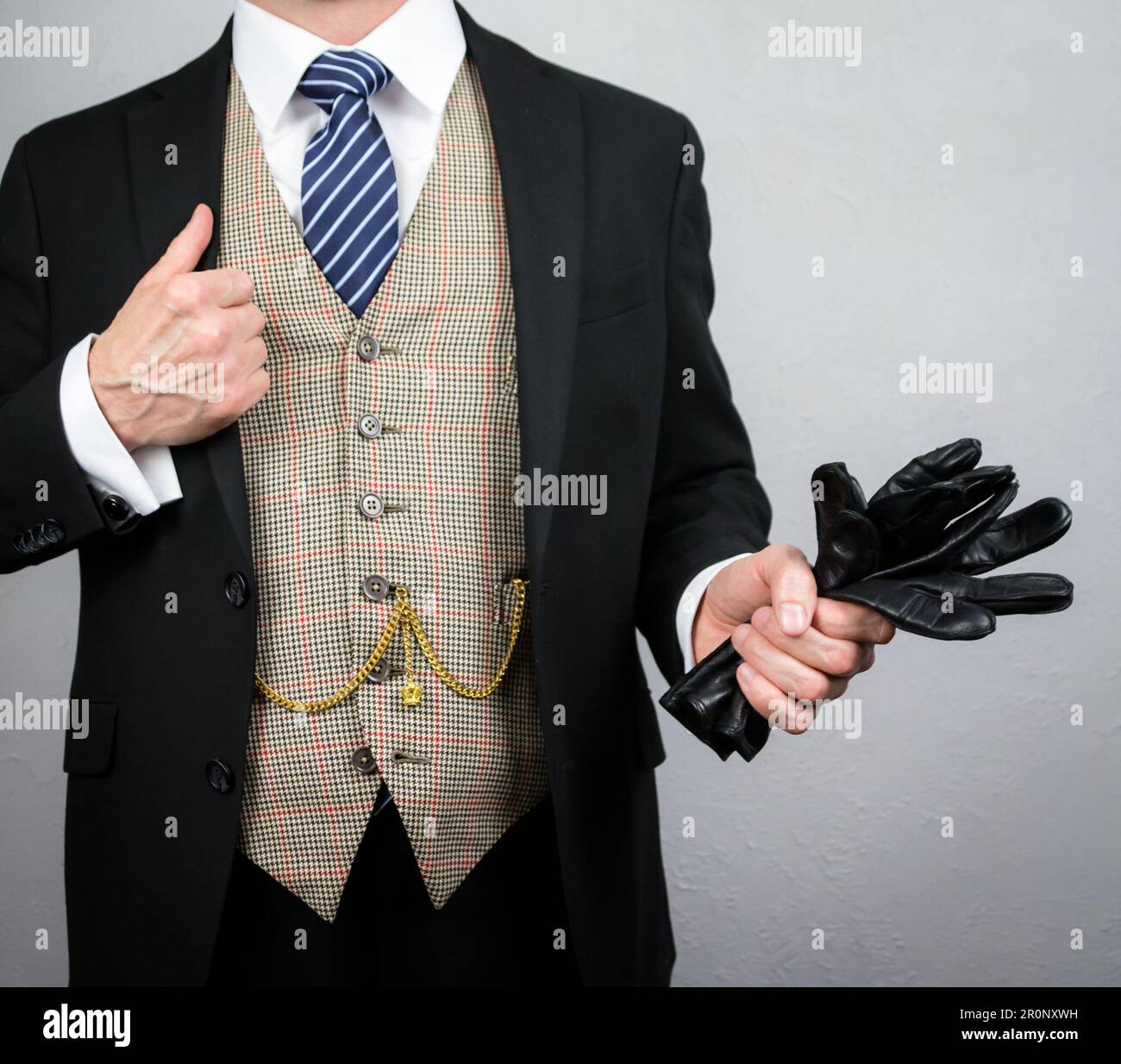 Portrait d'élégant Homme costume tenant des gants en cuir dans l'attitude de Carefree. Style vintage et mode élégante du gentleman britannique classique. Banque D'Images