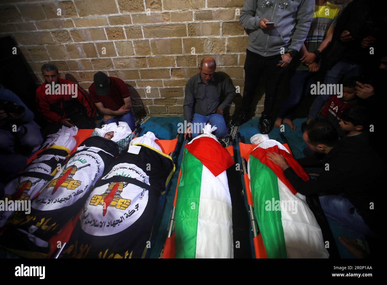 Gaza, Palestine. 9th mai 2023. Les boursouneurs se rassemblent autour du corps du garçon palestinien Ali Ezzedine, fils de Tarek Ezzedine, membre du Jihad islamique, dans une morgue de Gaza. Ils ont tous deux été tués lors d'un raid aérien israélien avant l'aube. L'armée israélienne a déclaré qu'elle avait tué trois dirigeants du groupe terroriste du Jihad islamique dans des frappes aériennes, qui ont fait au moins neuf morts selon le ministère de la santé du territoire palestinien contrôlé par le Hamas, ajoutant que les femmes et les enfants étaient parmi eux. Banque D'Images