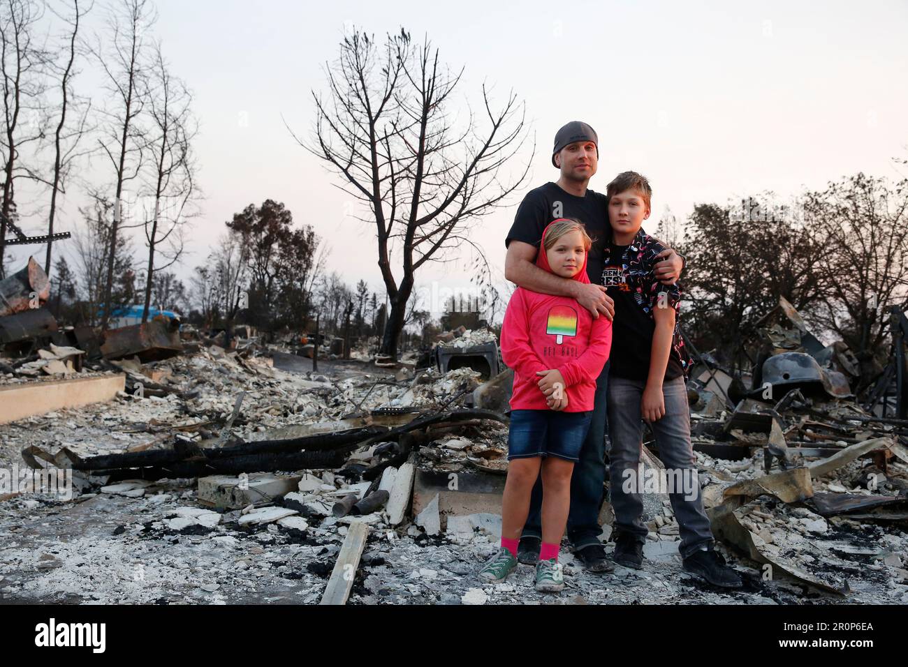 Jimmie Allen (center) stands with his children Miley Allen (left), 9 and Jaden Frank (right), 13, at their home in Coffey Park, which was burned in the Tubbs fire, on Wednesday, October 11, 2017 in Napa, Calif. (Lea Suzuki/San Francisco Chronicle via AP) Banque D'Images