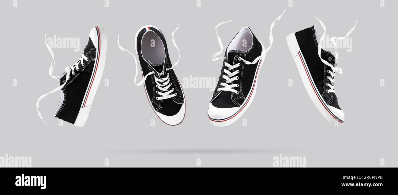 Baskets noires volantes de différents côtés sur fond gris. Chaussures de  sport tendance et élégantes. Design minimaliste et créatif avec chaussures.CRE  Photo Stock - Alamy