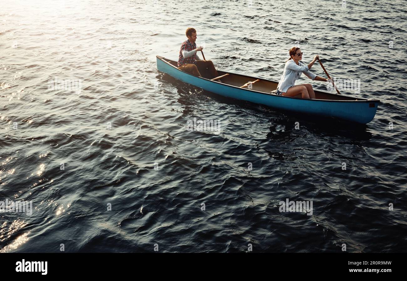 Il s'agit d'une zone sans stress. un jeune couple aviron un bateau sur le lac. Banque D'Images