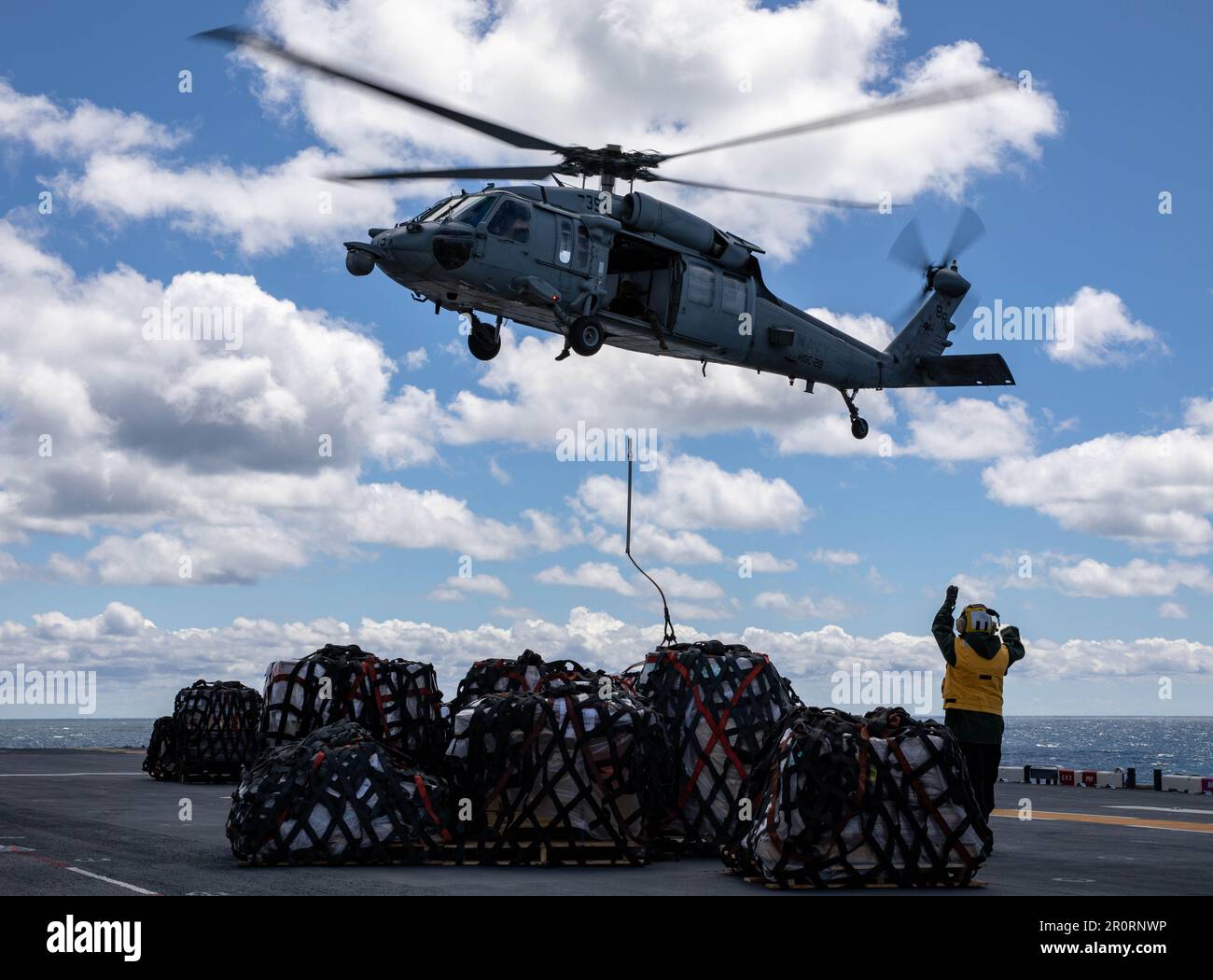 230504-N-XO158-1128 OCÉAN ATLANTIQUE (4 mai 2023) avion compagnon de bateau (manutention) Ian Francis Arevalo dirige un hélicoptère MH-60s Sea Hawk, affecté aux « baleines-dragons » de l’Escadron de combat en mer (HSC) 28, pour abaisser les provisions sur le pont de vol du navire d’assaut amphibie USS Wasp (LHD 1) Lors d'une reconstitution verticale (VERTREP) avec le navire de soutien de combat USNS Supply (T-AOE-6), 4 mai 2023. Wasp procède actuellement à des inspections et à des évaluations de la phase de base. (É.-U. Photo de la marine par le spécialiste des communications de masse 2nd classe Sydney Milligan) Banque D'Images