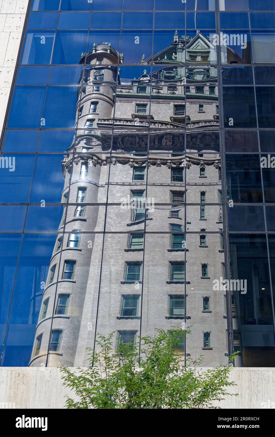 Le Plaza Hotel se reflète dans la façade de verre incurvée du Solow Building, dans Midtown Manhattan. Banque D'Images