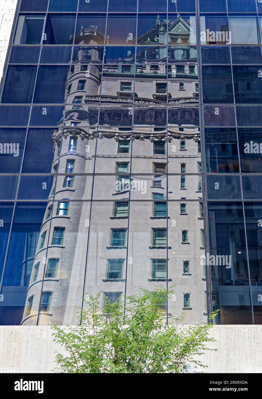 Le Plaza Hotel se reflète dans la façade de verre incurvée du Solow Building, dans Midtown Manhattan. Banque D'Images