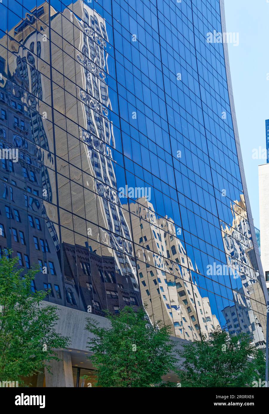 Le Park Lane Hotel se reflète dans la façade en verre incurvée du Solow Building, dans Midtown Manhattan. Banque D'Images