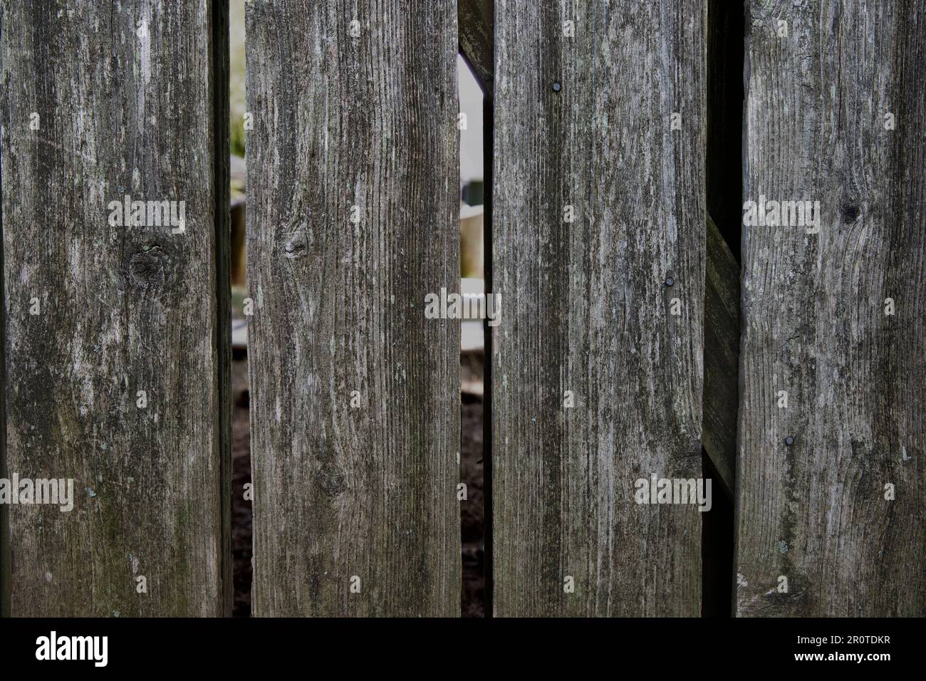 gros plan d'une clôture abîmée avec des espaces entre les lattes Banque D'Images