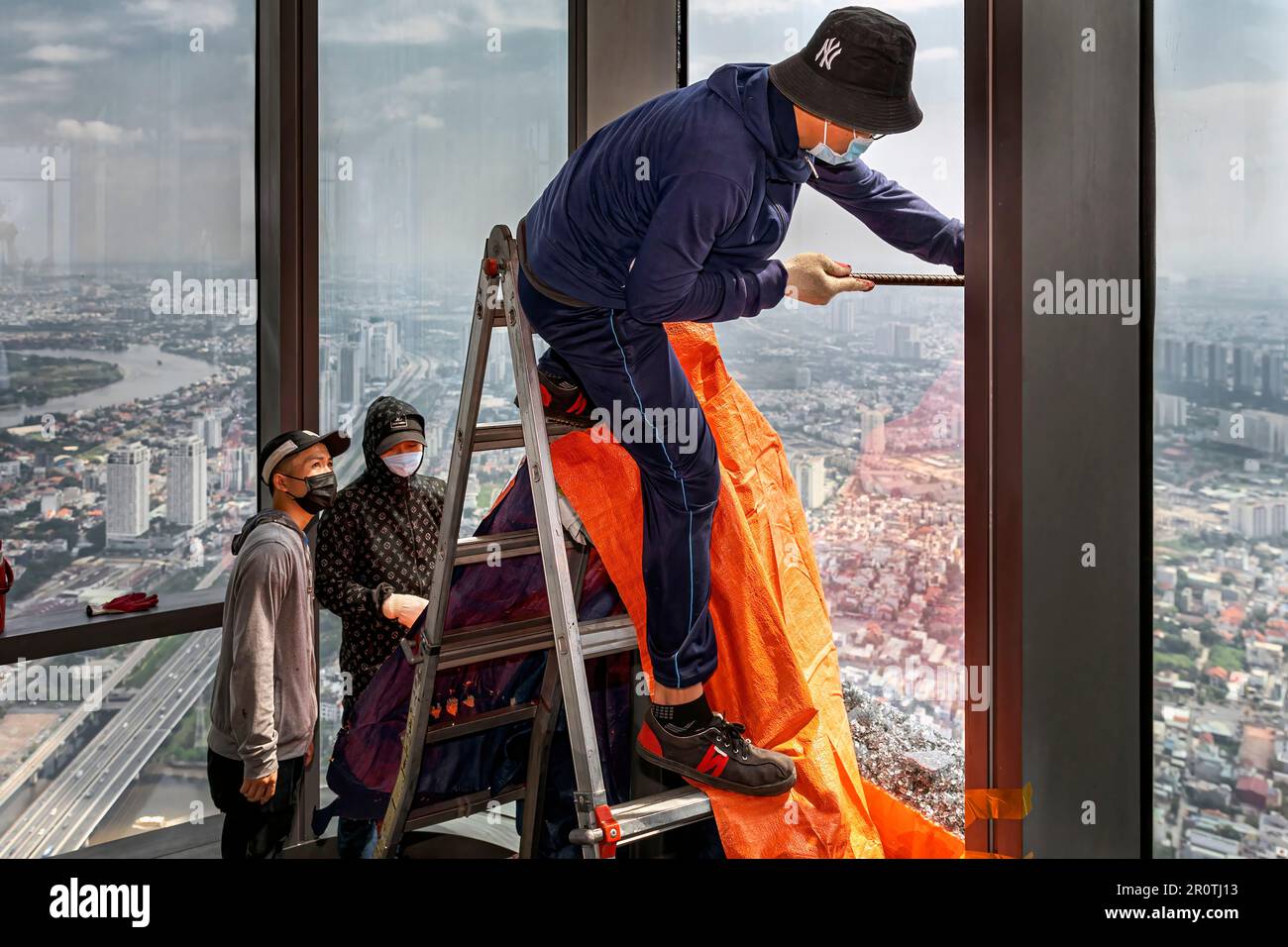 Travailleurs vietnamiens remplaçant la vitre brisée de la tour Landmark 81, Ho Chi Minh ville, Vietnam Banque D'Images