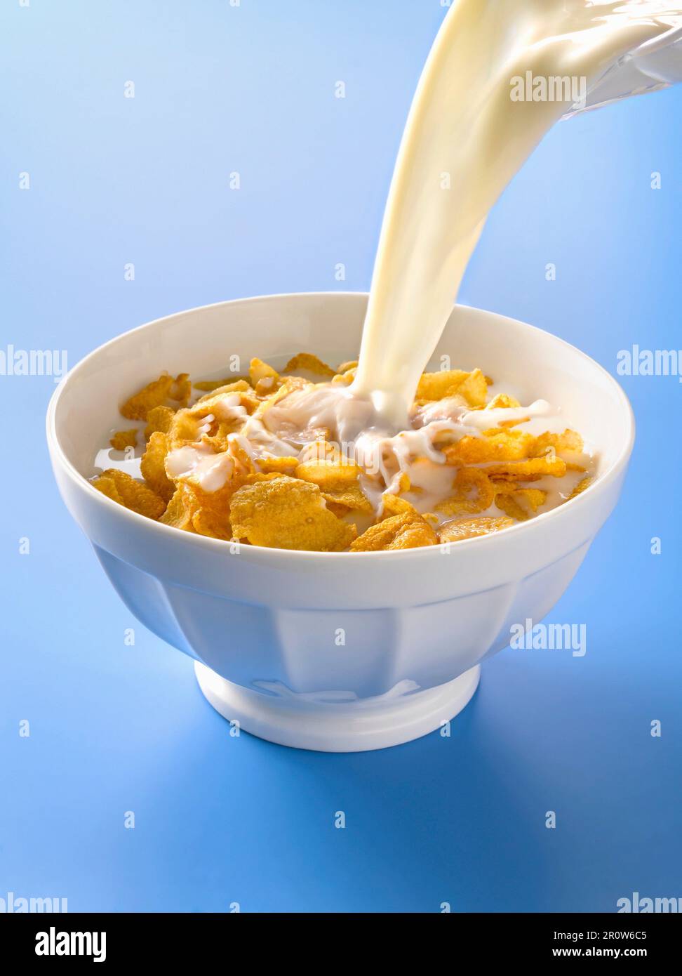 Verser le lait dans un bol de cornflakes Banque D'Images