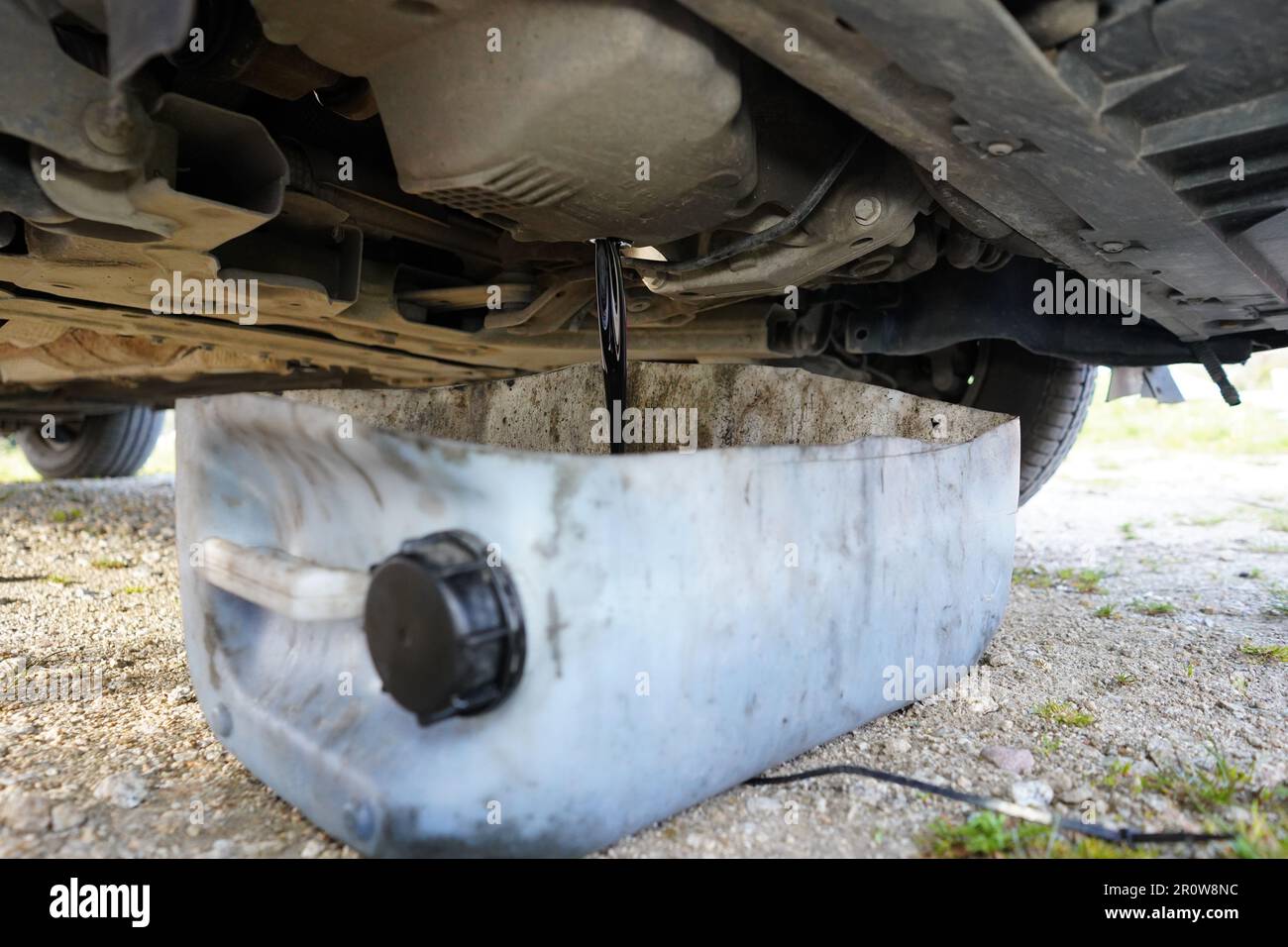 Huile usagée noire vidangée du moteur de la voiture. Vidange de l'huile de voiture usagée. Vidange d'huile dans la voiture. Vidange d'huile de voiture. Banque D'Images
