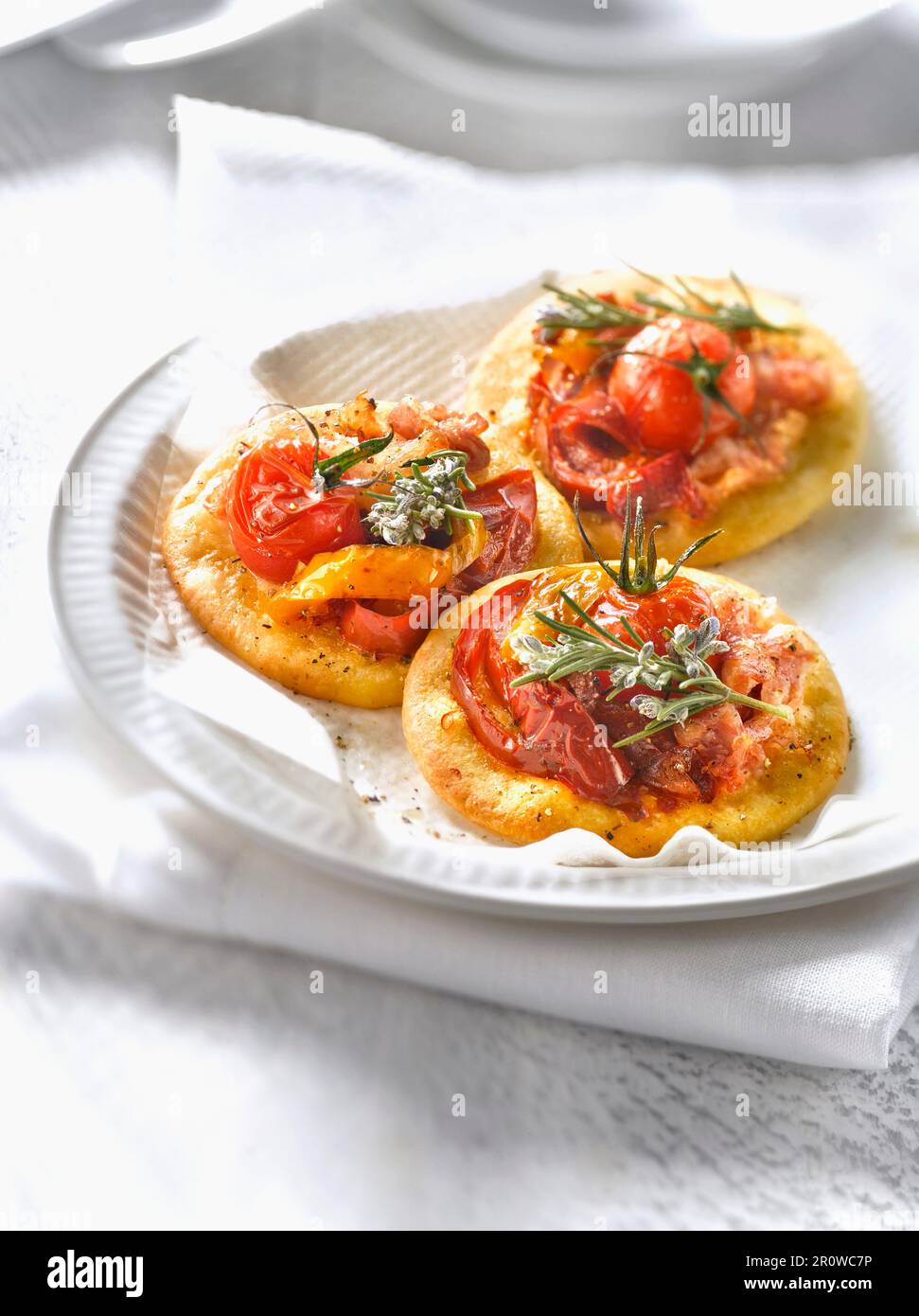 Mini-pizzas de tomates cerises, de pancetta et de poivrons grillés Banque D'Images