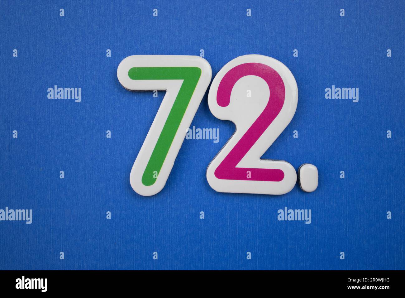 Le numéro 72, placé sur un fond bleu, photographié par le dessus, de couleur verte et rouge. Banque D'Images