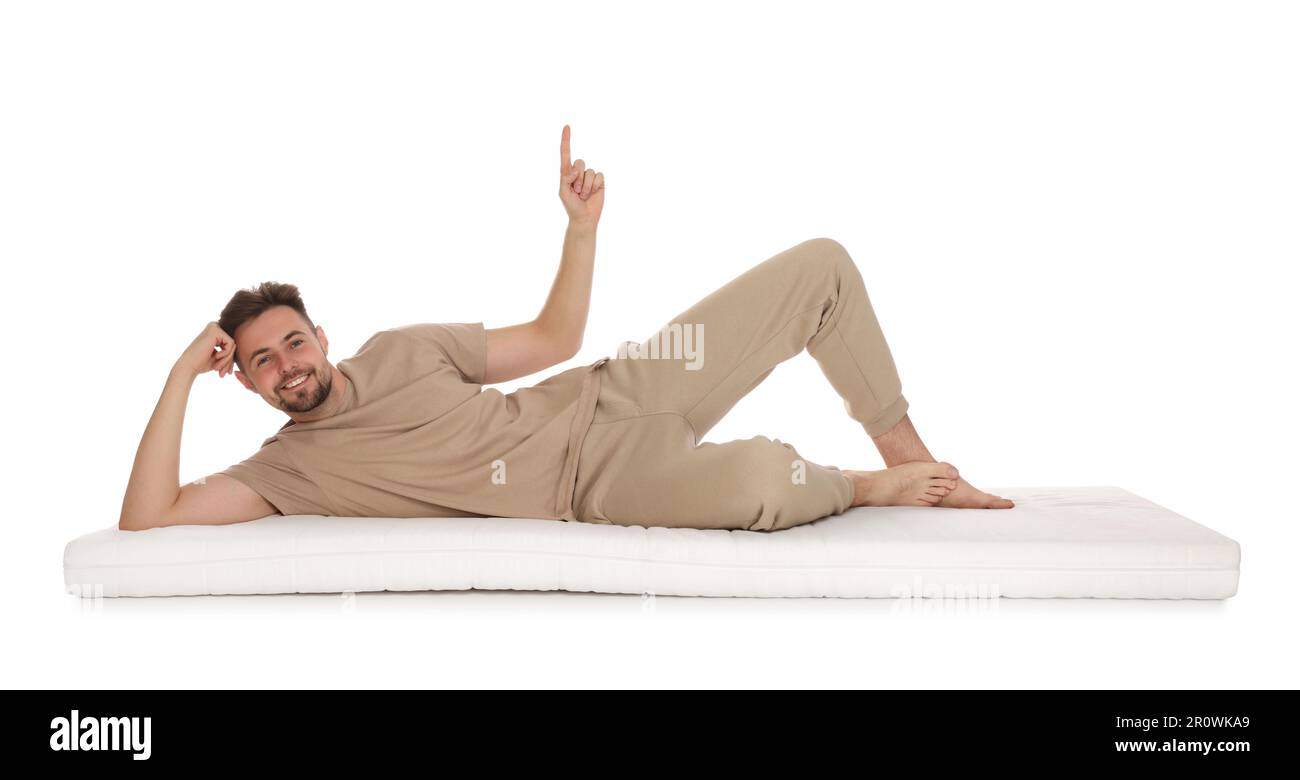 Homme allongé sur un matelas souple et pointant vers le haut sur fond blanc  Photo Stock - Alamy