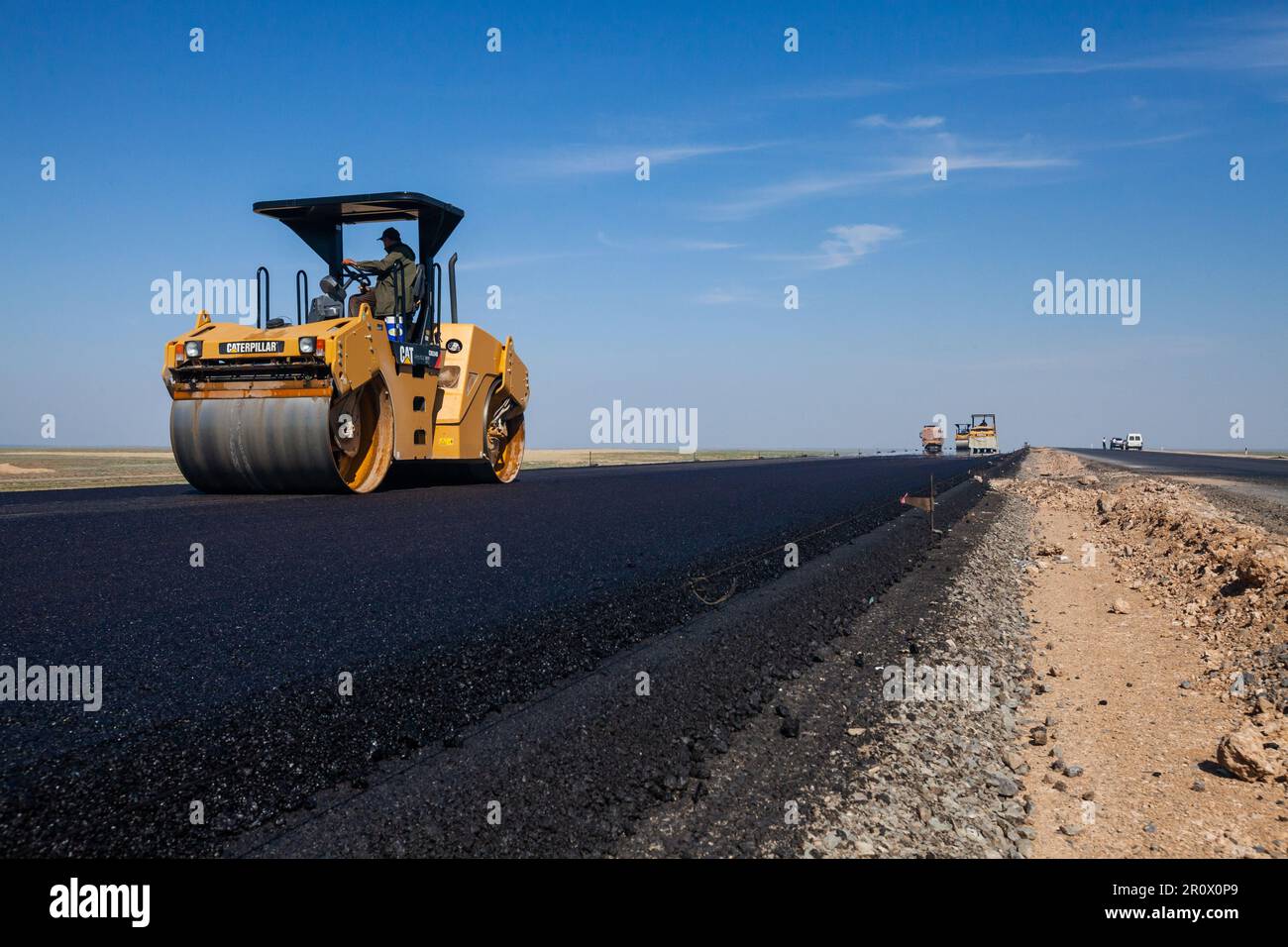 Province de Kyzylorda, Kazakhstan, 29 avril 2012 : le compacteur d'asphalte Caterpillar aplatit l'asphalte. Construction de l'autoroute Europe occidentale-Chine occidentale Banque D'Images