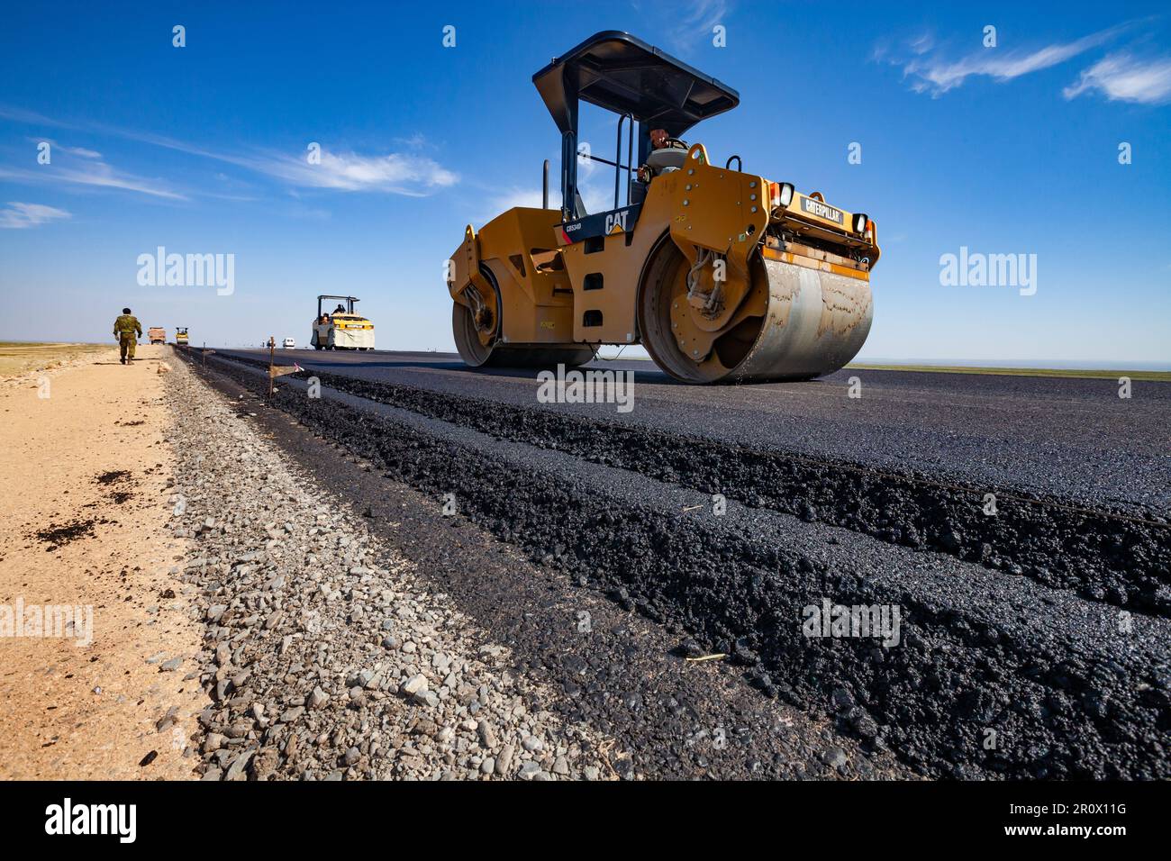 Province de Kyzylorda, Kazakhstan, 29 avril 2012 : construction de la route Europe occidentale-Chine occidentale. Le compacteur tandem vibrant Caterpillar aplatit les couches d'asphalte Banque D'Images