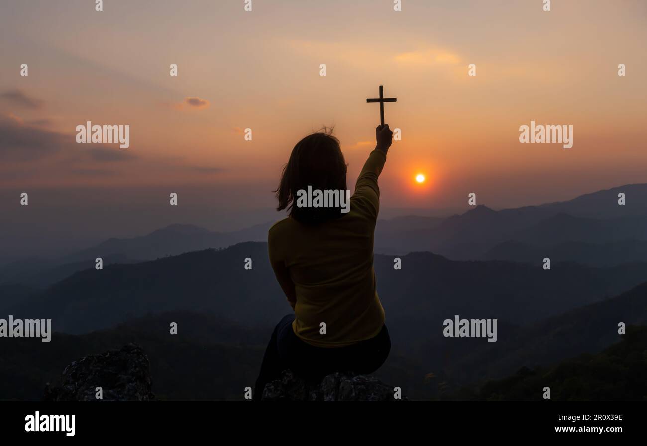 Femme en prière chrétienne culte au coucher du soleil. Mains jointes en prière. adorer Dieu avec conception chrétienne de la religion. Banque D'Images