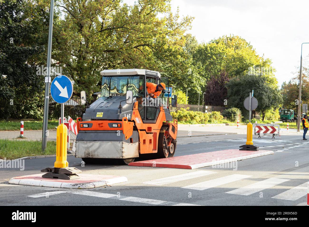 VARSOVIE, POLOGNE - 10 MAI 2023 : des techniciens sont engagés dans la pose d'asphalte. Réparation de la surface de la route, pose d'asphalte. Le rouleau roulant roule et fait le niveau de l'asphalte Banque D'Images