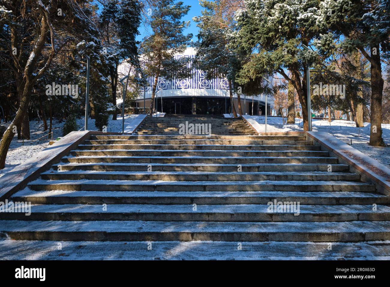 Les marches qui mènent au rond, circulaire Musée de la gloire olympique. Juste après une tempête d'hiver a laissé une poussière blanche et légère de neige fraîche. À Tashk Banque D'Images