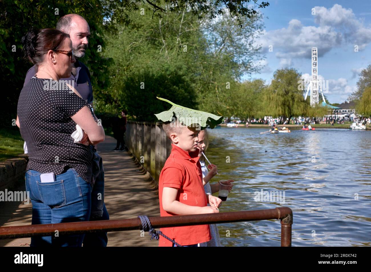 Enfant improvisant en utilisant une grande feuille comme un store pour protéger sa tête contre le soleil. Angleterre Royaume-Uni Banque D'Images