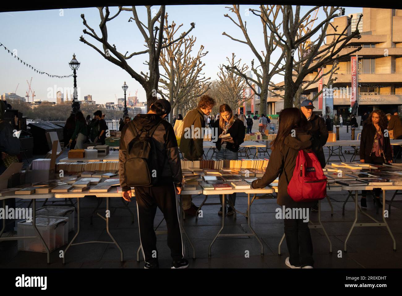 South Bank Book Market, les touristes s'arrêtent pour parcourir un marché de livres en plein air consacré uniquement aux livres situés sous le Waterloo Bridge, Londres, Royaume-Uni Banque D'Images