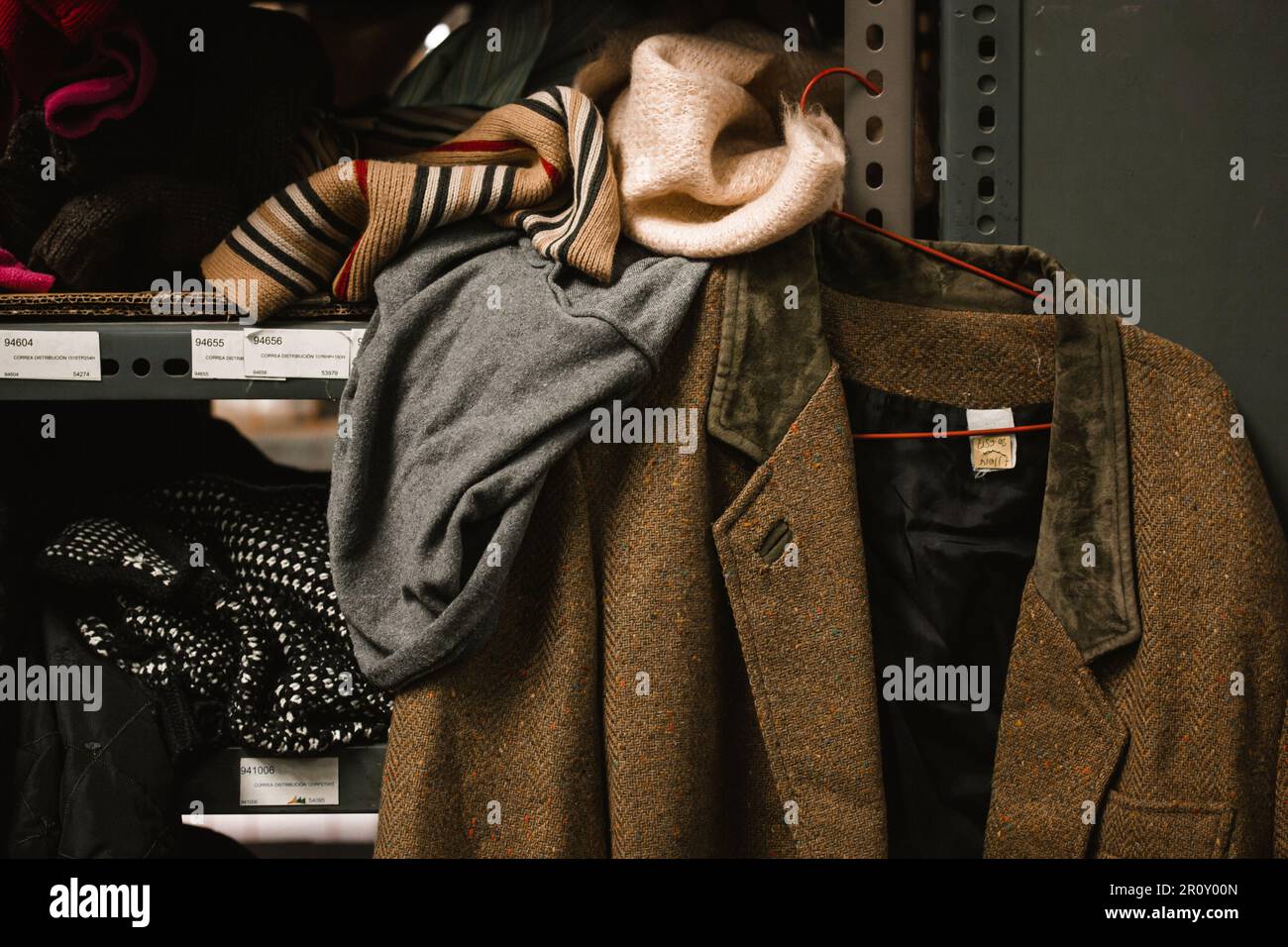 Madrid, Espagne. 1 mai 2022 une vieille veste de laine brune est suspendue sur un rack dans un entrepôt de vêtements d'occasion. Point de distribution de l'aide humanitaire pour refuge Banque D'Images
