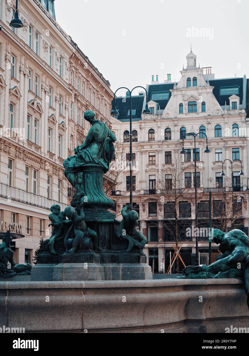 Une statue en marbre angélique se trouve au centre d'une cour entourée de grands bâtiments en briques Banque D'Images