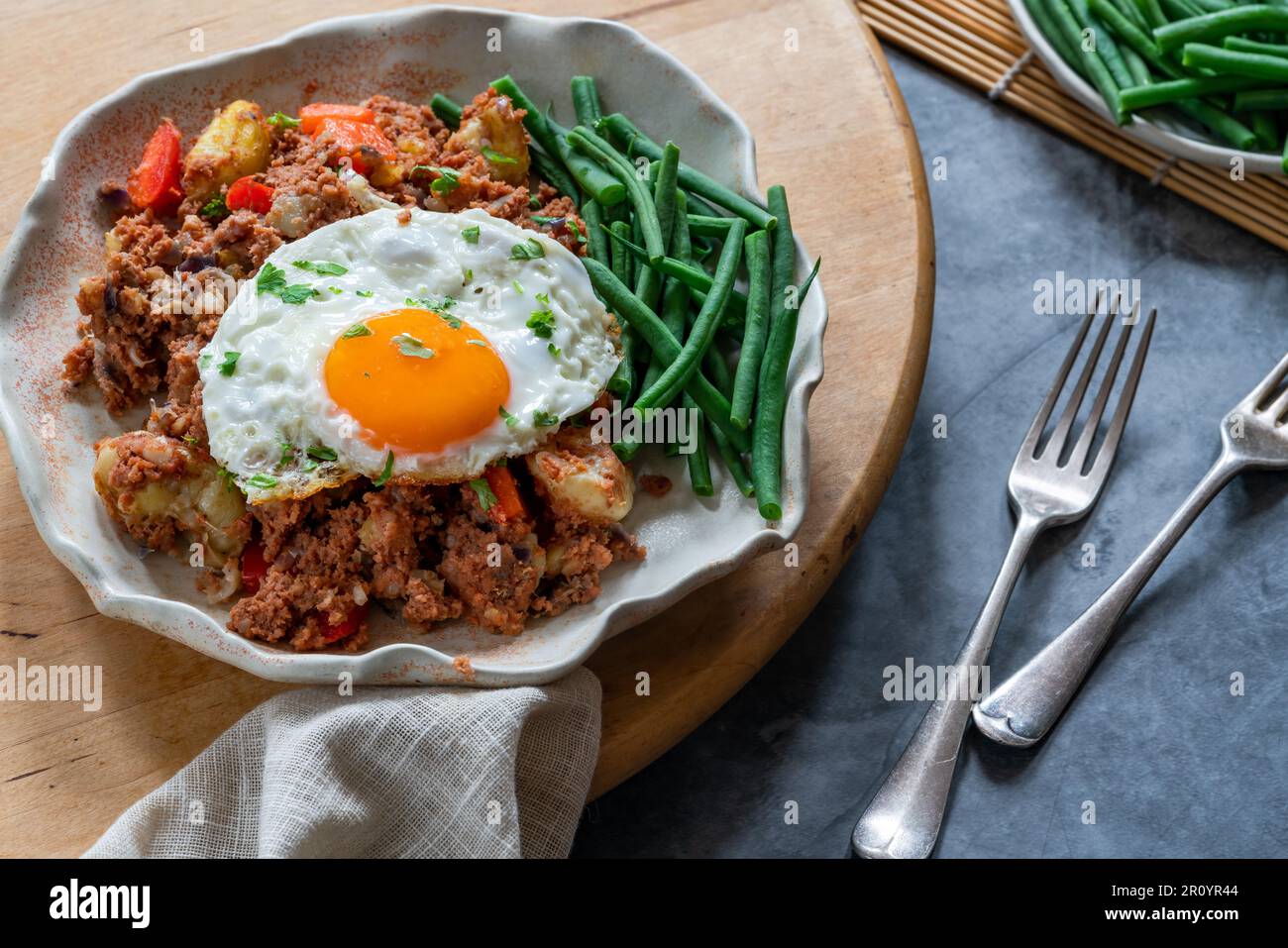 Hachis de bœuf corned avec œuf frit et haricots verts Banque D'Images