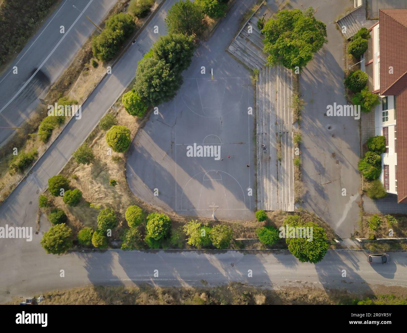 Vue aérienne d'un vaste parc de stationnement vide de la ville, avec des rangées de places de stationnement et une route sinueuse qui s'éloigne du parc Banque D'Images