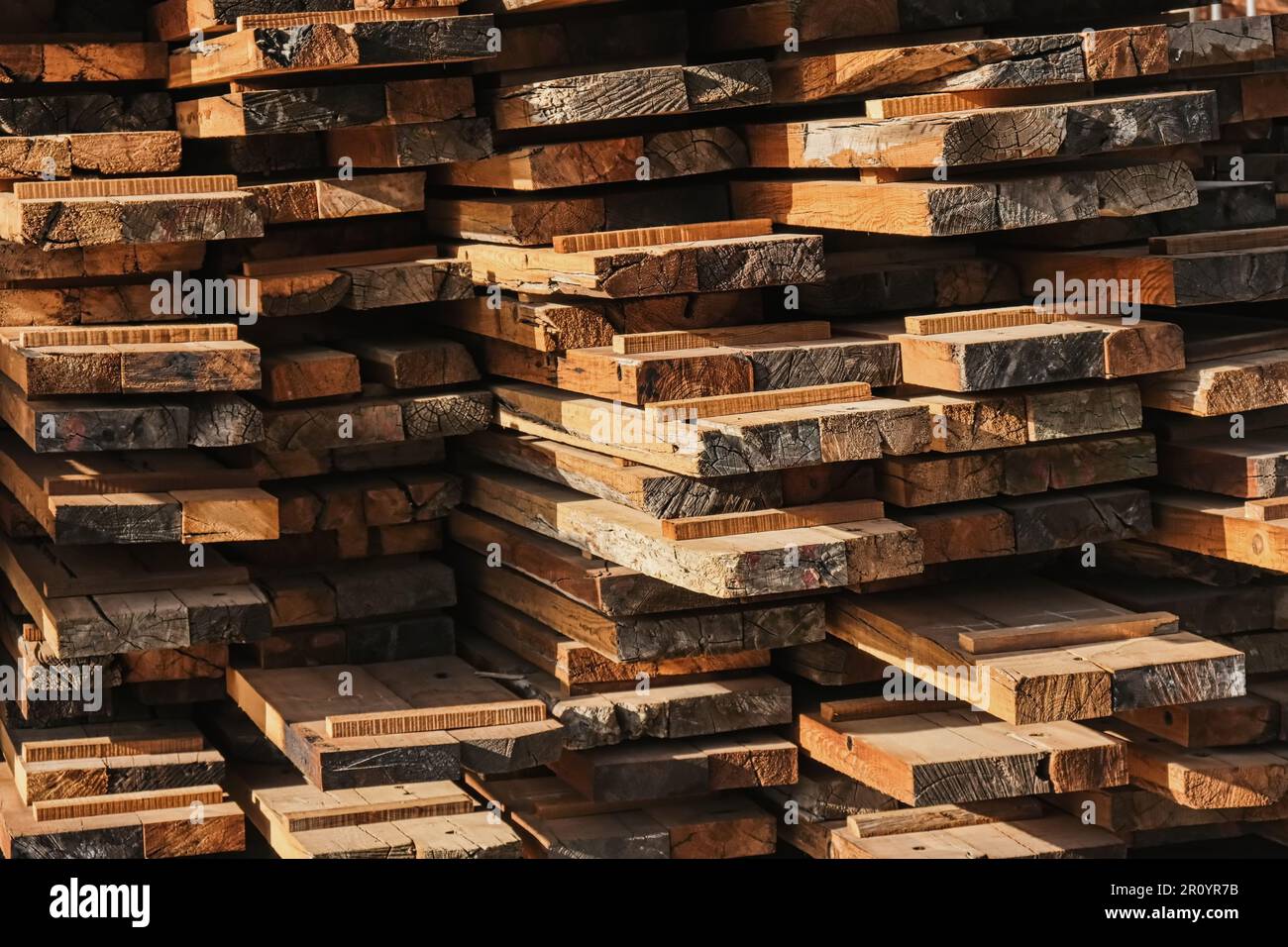 Tas de planches en bois comme arrière-plan. Pile de bois séchant à l'air. Entrepôt extérieur en bois. Pile de planches en bois dans une scierie, planches, planches à scier. Banque D'Images