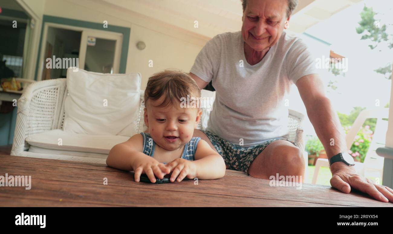 Grand-parent et bébé interaction avec la famille, décontracté et authentique Banque D'Images