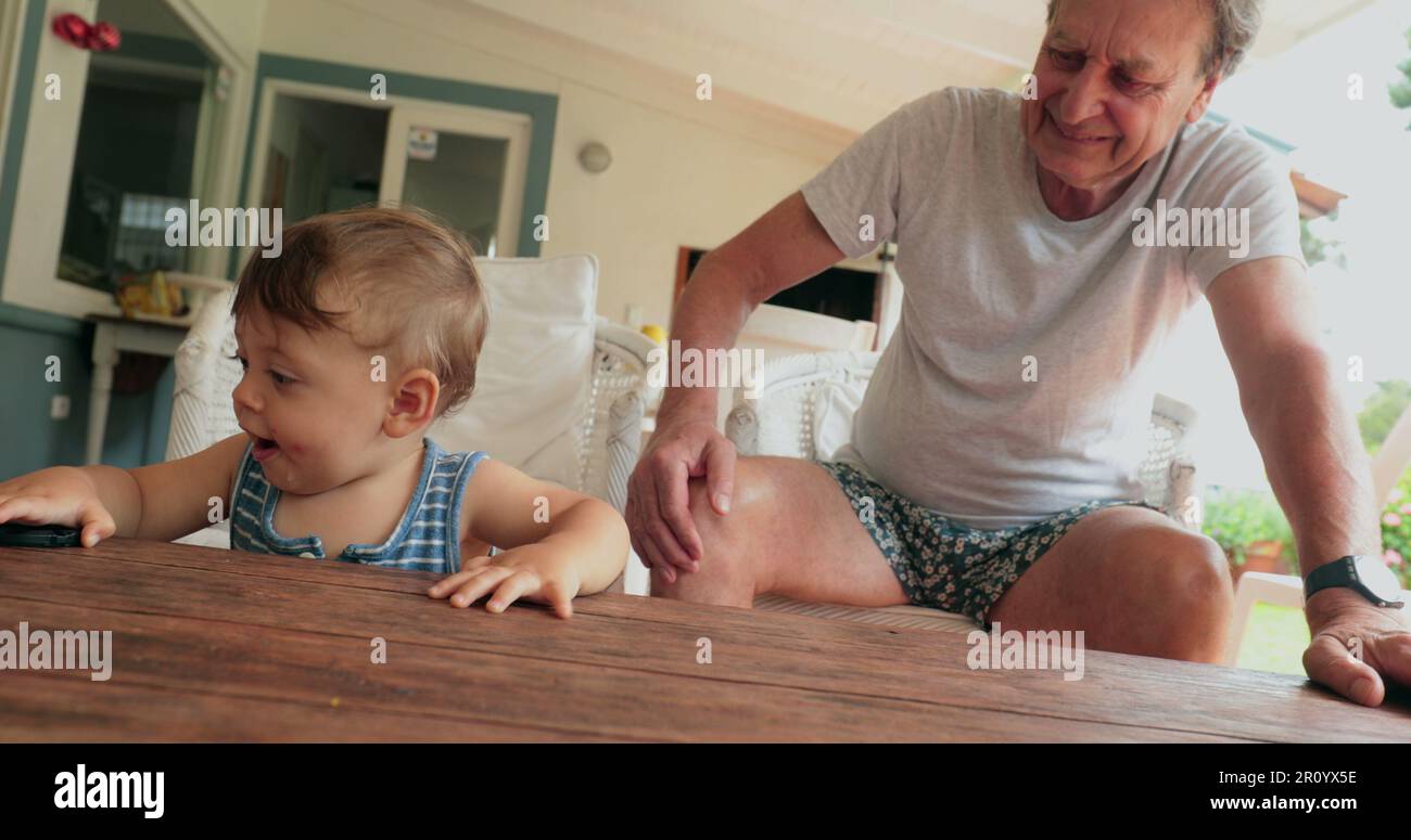 Grand-parent et bébé interaction avec la famille, décontracté et authentique Banque D'Images