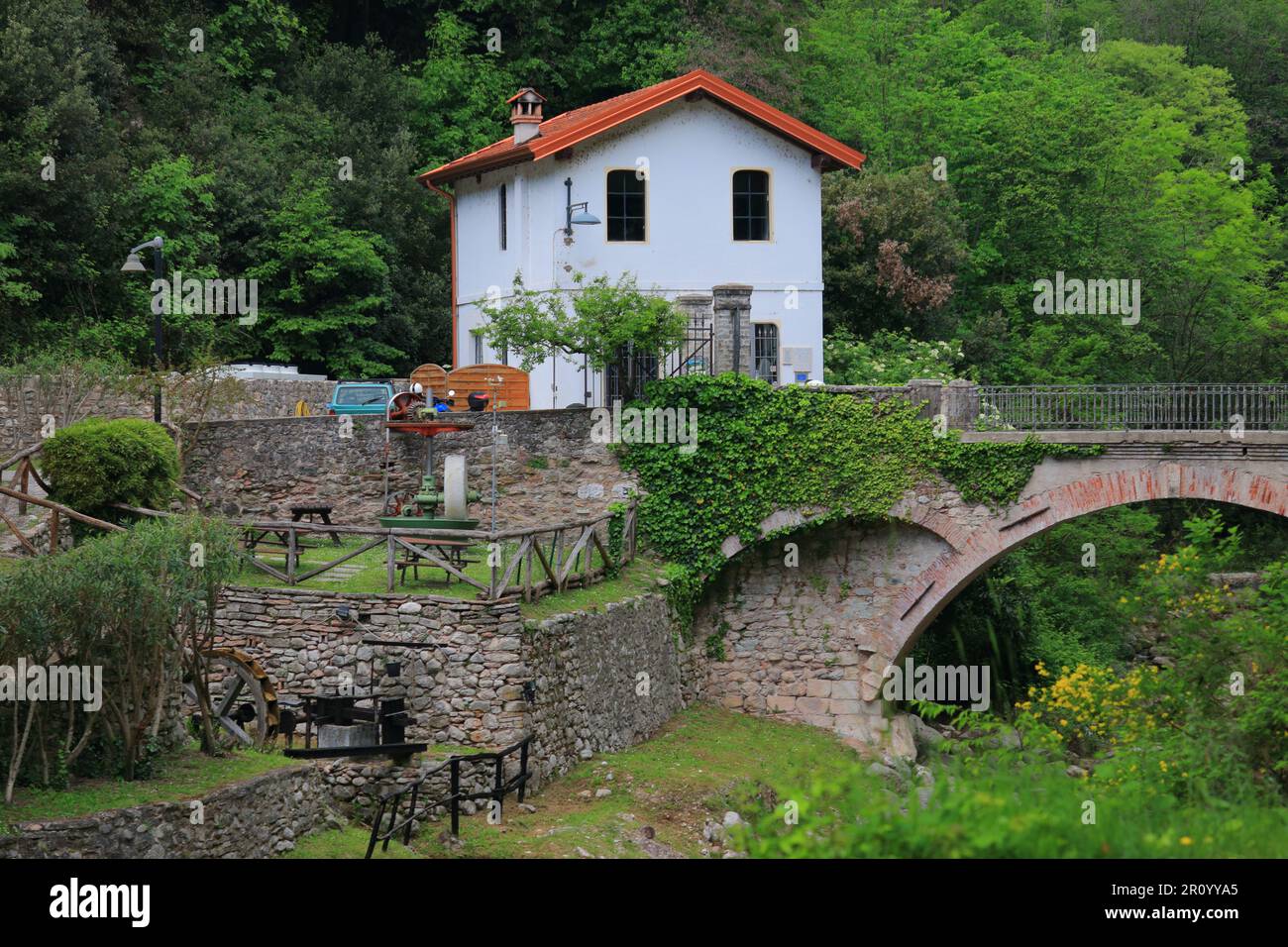 Une maison blanche avec un toit orange à côté d'un vieux pont voûté dans la vallée des papeteries. Maderno, Italie. Banque D'Images