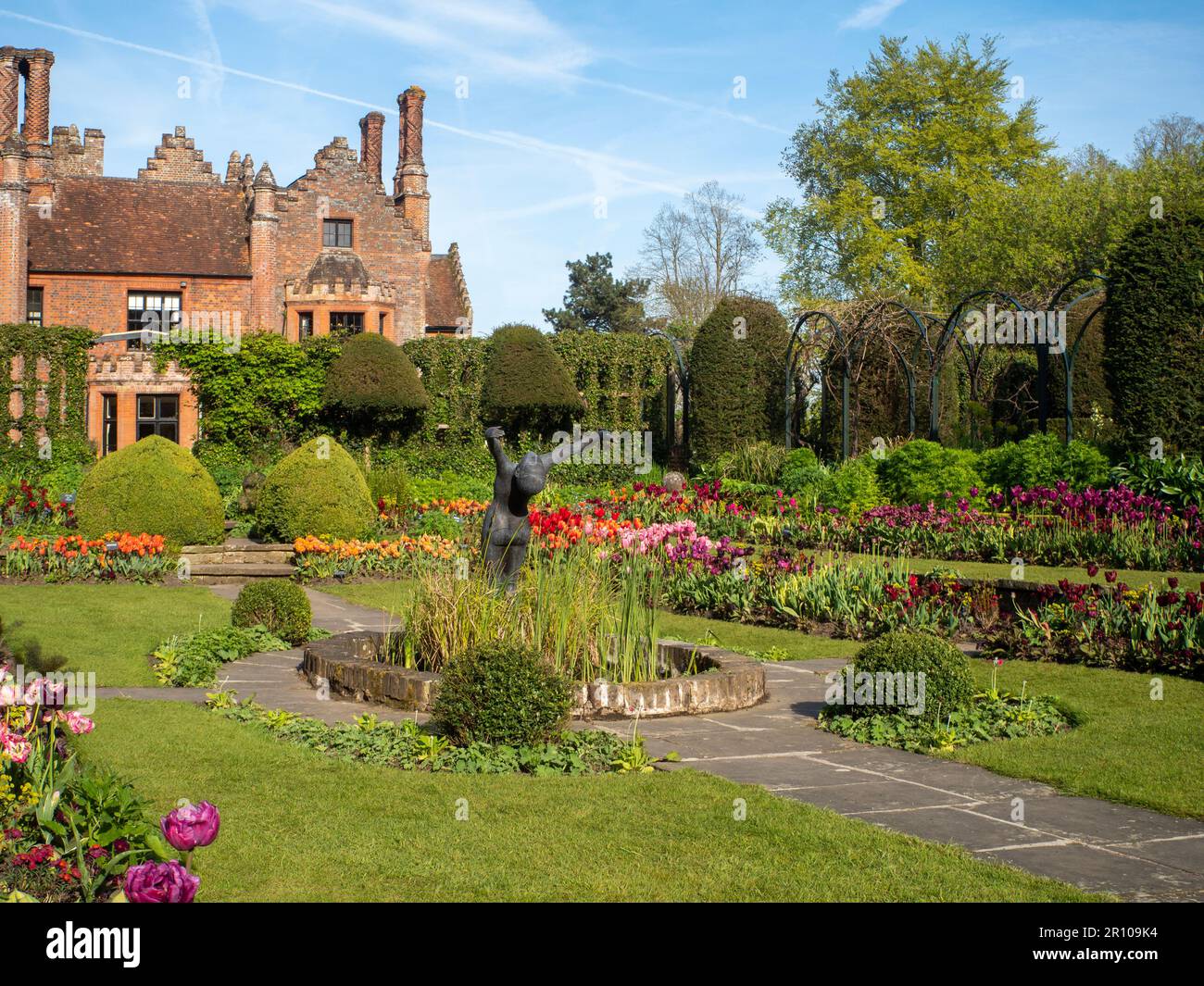 Chenies Manor Garden Tulips en mai. Des tulipes rouges, orange et roses vibrantes plantées en couches dans le jardin en contrebas en terrasse un après-midi agréable. Banque D'Images