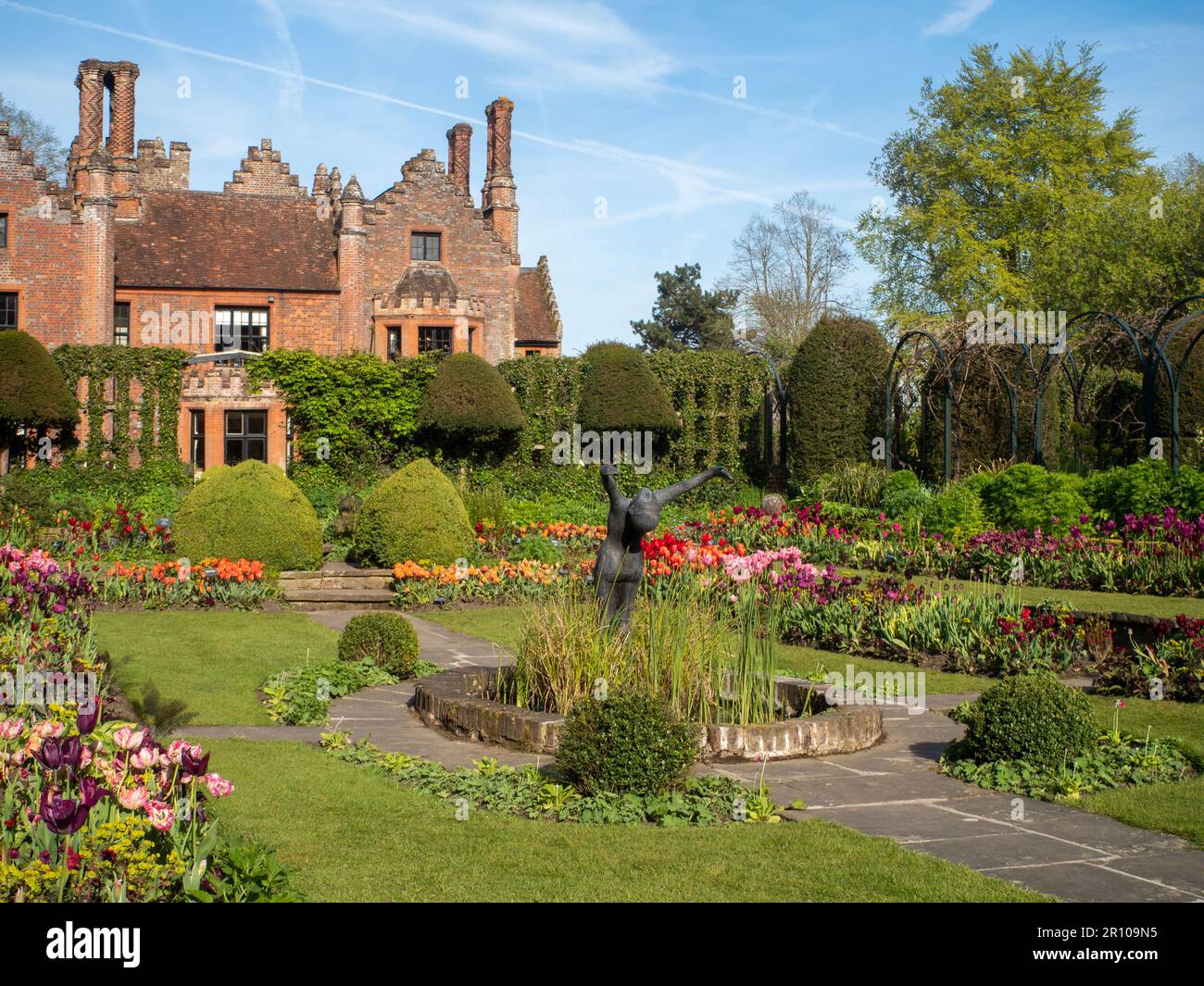 Chenies Manor Garden Tulips en mai. Des tulipes rouges, orange et roses vibrantes plantées en couches dans le jardin en contrebas en terrasse un après-midi agréable. Banque D'Images