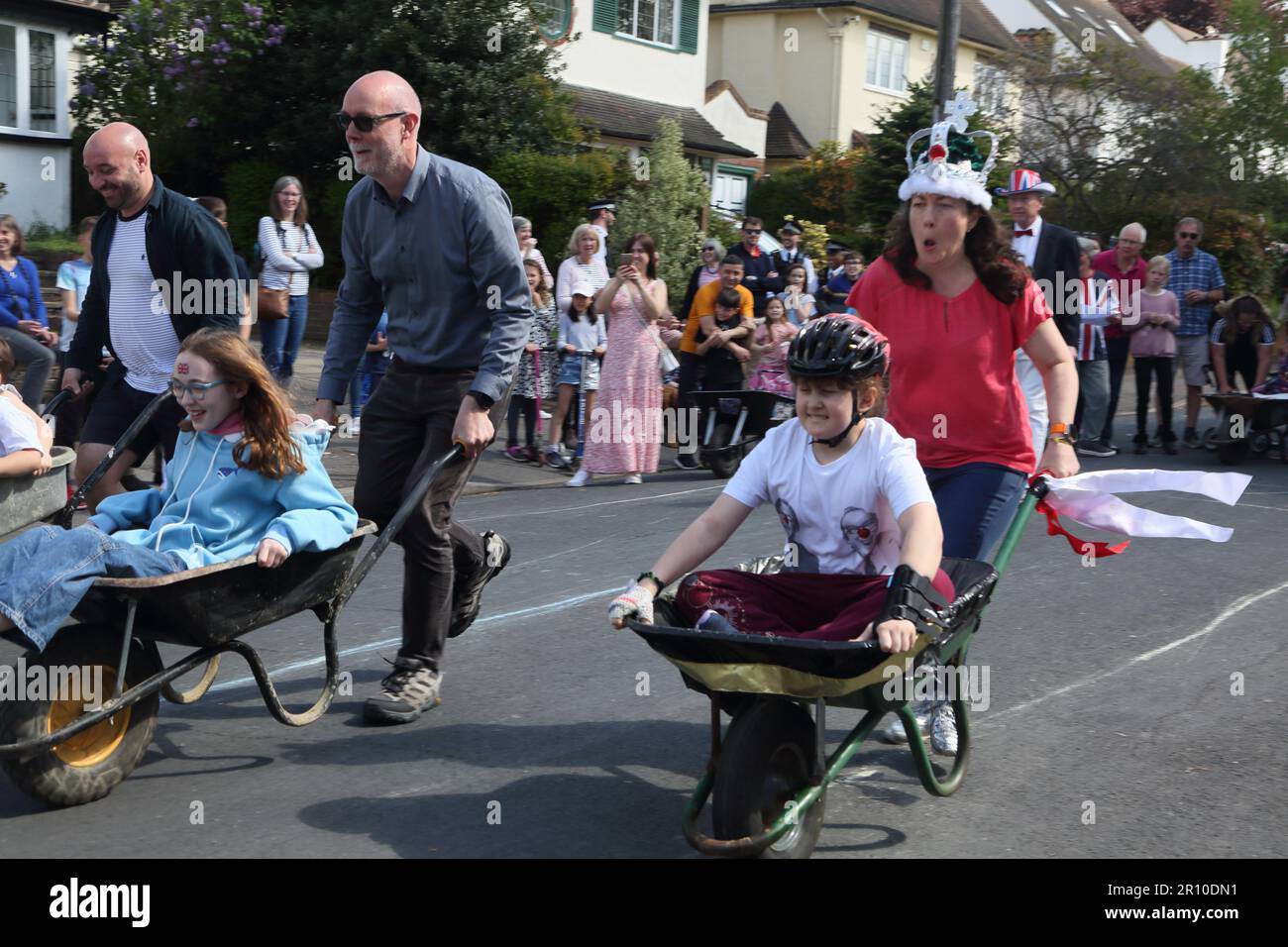 Familles participant à la course de brouettes à Street Party célébrant le Roi Charles III Coronation Surrey Angleterre Banque D'Images