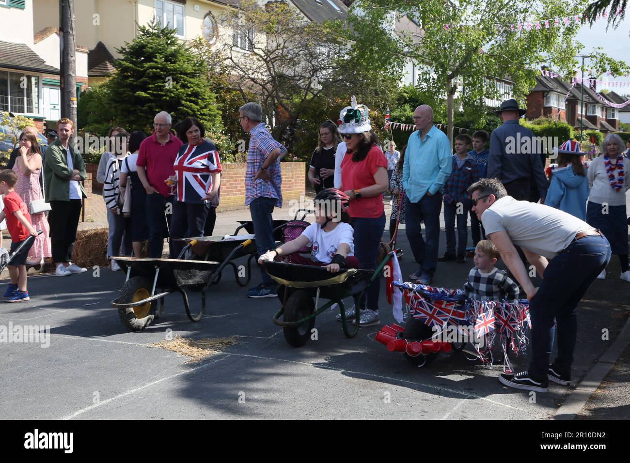 Familles participant à la course de brouettes à Street Party célébrant le Roi Charles III Coronation Surrey Angleterre Banque D'Images