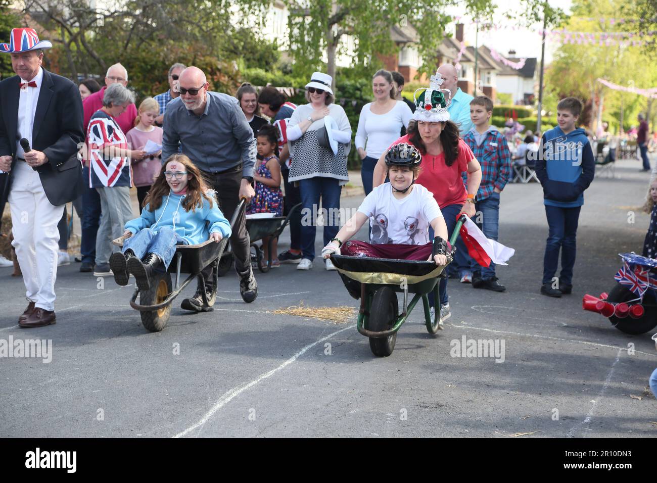 Familles participant à la course de brouettes à Street Party célébrant le Roi Charles III Coronation Surrey Angleterre Banque D'Images
