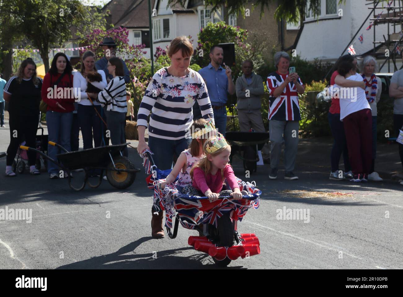 Familles participant à la course de brouettes à Street Party célébrant le Roi Charles III Coronation Surrey Angleterre Banque D'Images